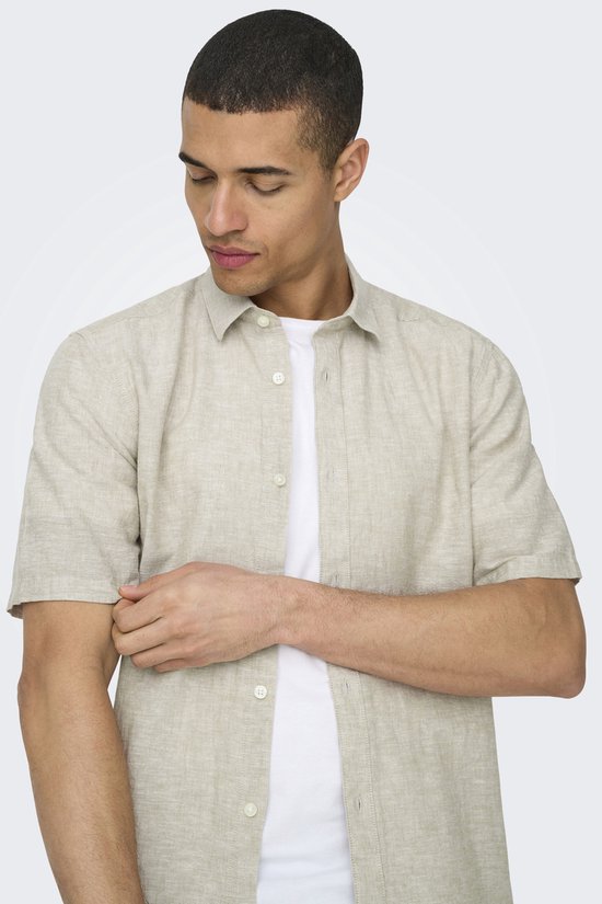 Man met korte mouwen, lichtbeige linnen mix overhemd met witte t-shirt.