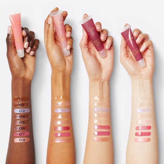 Vier armen met verschillende huidtinten tonen swatchs van Lancôme Juicy Tubes lipgloss, met tubes in de handen en nummers op de huid.