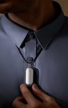 Man in grijs overhemd met de zilverkleurige Plaude NotePin als ketting.