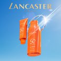 Lancaster Sun Beauty Face Cream tube en body milk fles. Zonnige achtergrond.