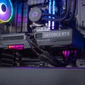 Computer met een 'GEFORCE RTX' grafische kaart, 'GAMINGPRO' logo en verlichte ventilatoren met blauwe en paarse tinten.