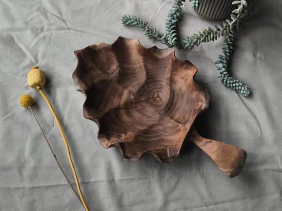 Houten fruitschaal met grillige rand, handvat en een gedroogde papavers en plant.