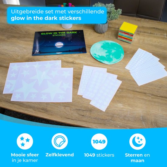 Een tafel met diverse glow-in-the-dark stickers, waaronder grote sterren, kleine sterren, stippen en een lichtgevende maan.