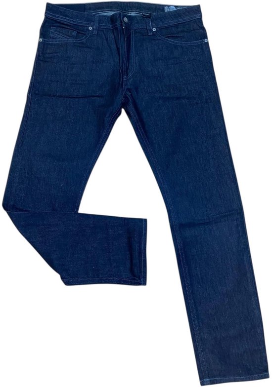 Donkerblauwe Diesel jeans met rechte pijpen, de linker broekspijp is gebogen.