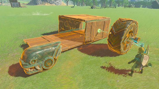 Link bouwt een voertuig met houten planken, een steen met gezicht en een groot wiel in een groen grasveld.