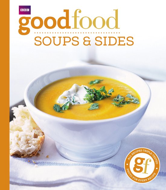 Kookboek 'Good Food Soups & Sides' met een kom oranje soep, gegarneerd met room en peterselie, naast een stuk brood.