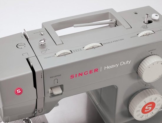 Grijze Singer Heavy Duty naaimachine, close-up van de bedieningsknoppen en handvat.