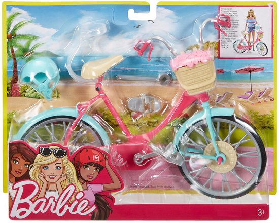 Roze Barbie fiets met lichtblauwe spatborden en velgen, rieten mandje met bloemen en helm.
