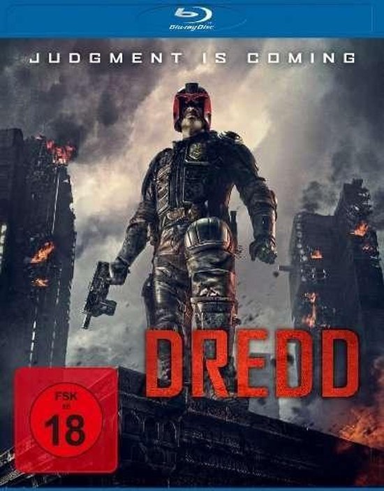 Dredd: Un homme en armure rouge/noire avec un casque se tient sur un bâtiment, tenant une arme. Les bâtiments environnants sont détruits.