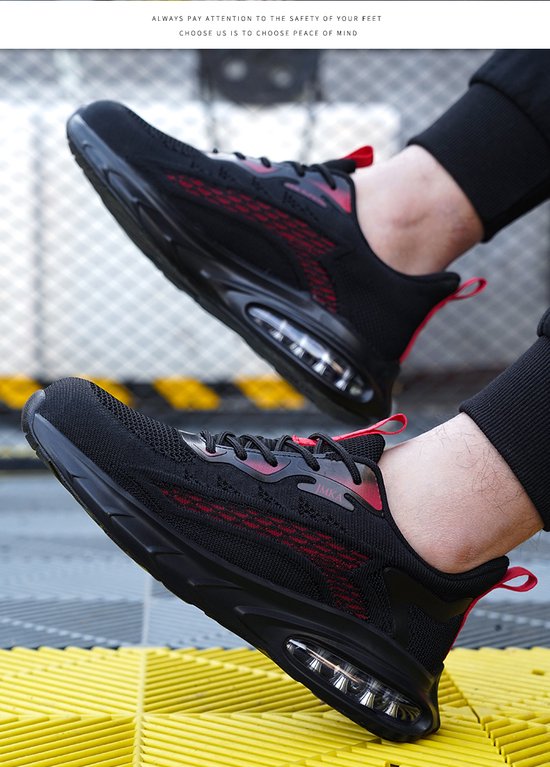 Gros plan d'une personne portant des chaussures de travail noires avec des accents rouges et une semelle à coussin d'air.