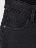 Close-up van de donkergrijze jeans met logo-knop.