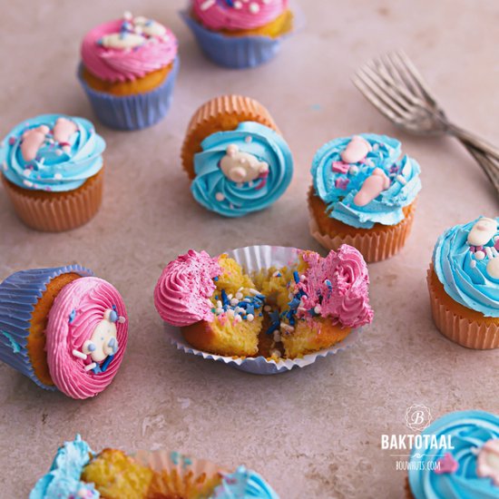 Roze en blauwe cupcakes met beren decoratie, sommige door midden gebroken.