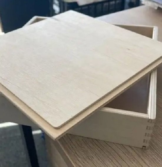 Open houten bak met het deksel schuin ernaast, beide met zichtbare houtnerven en verbindingen aan de zijkanten.