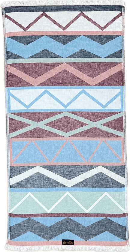 Strandlaken met een geometrisch patroon in pastelkleuren. Kleuren: wit, roze, blauw, groen, grijs. Met franjes.