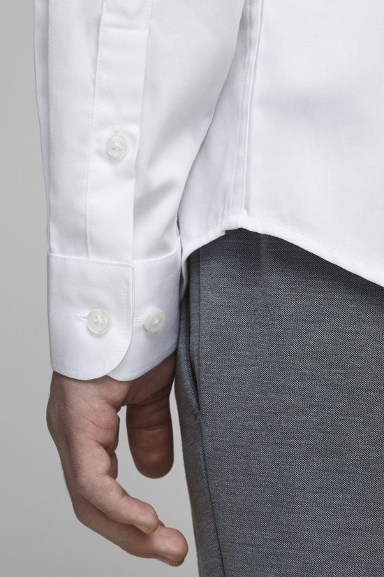 Manche d'une chemise blanche en coton avec des boutons blancs.