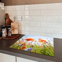 Een inductiebeschermer met klaprozen en korenbloemen op een aanrecht.