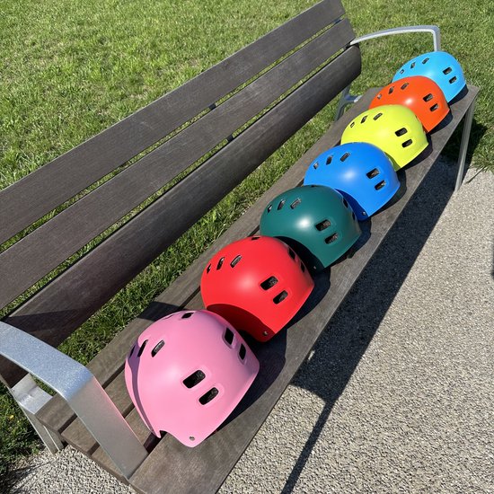 Six casques PRO Sport Lights de différentes couleurs sur un banc en bois.