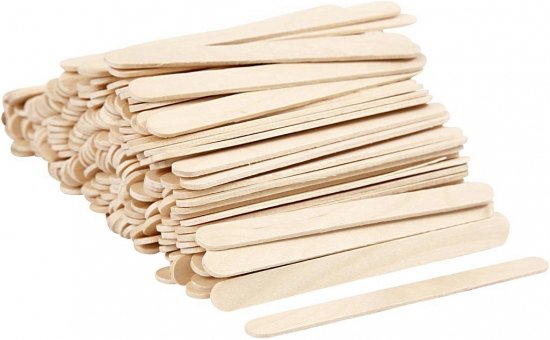 Een stapel naturel houten ijsstokjes op een witte achtergrond. Een stokje ligt apart vooraan.