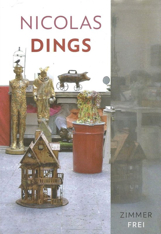Boek 'Nicolas Dings - Zimmer Frei' met twee gouden beelden, een speelgoedhuisje en een varkenswagen.