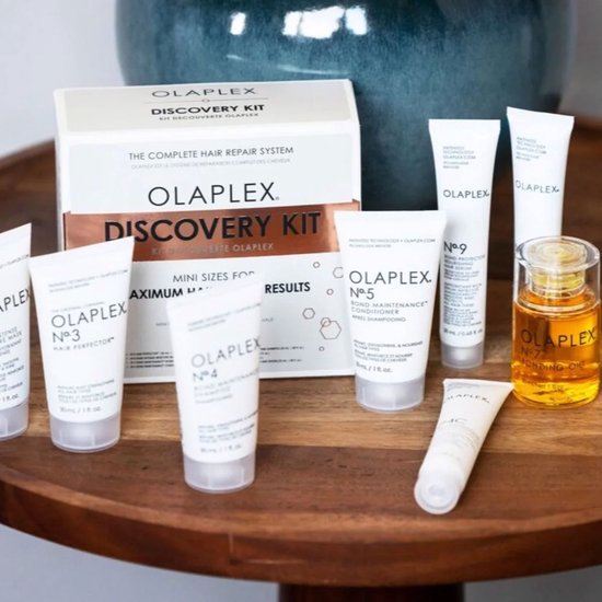 Olaplex Discovery Kit op een houten tafel. De set bevat 7 mini-producten en de No.7 Bonding Oil.