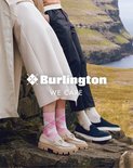 Mensen die buiten op rotsen staan, met op de voorgrond een vrouw met roze ruitersokken en beige loafers, en een man met donkere loafers.