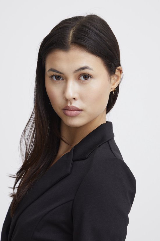 Model draagt een zwarte Ichi blazer met een enkele knoopsluiting. Haar donkere haar valt over haar schouder.