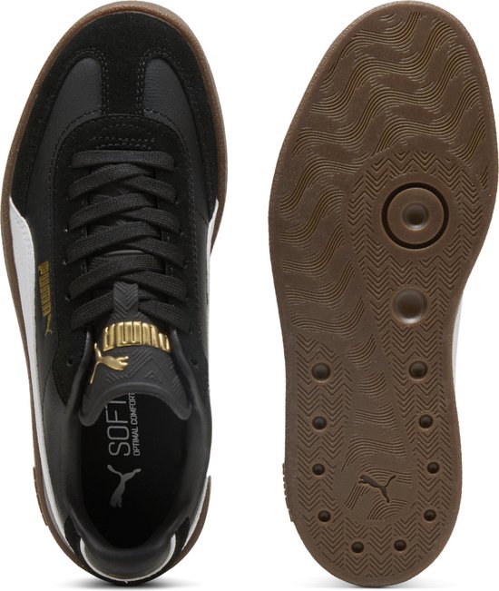 Zicht op de binnen- en buitenzool van een zwarte Puma sneaker met witte streep, gouden logo en bruine zool.