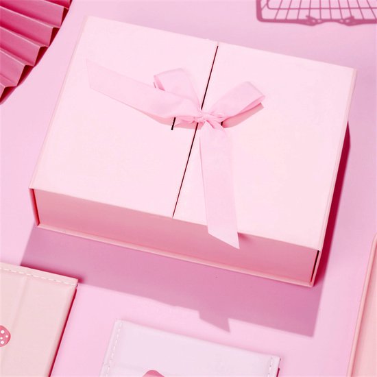 Boîte cadeau pliante rose avec un nœud rose pâle.