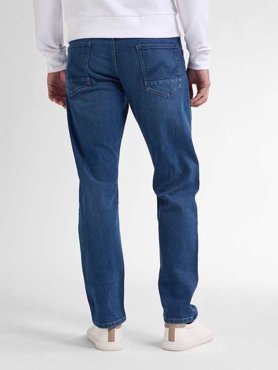 Detailopname van de achterzakken van de blauwe jeans op het model.