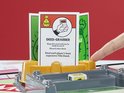 Vinger wijst naar 'Deed-Grabber' kaart bij Monopoly Uitbreiding Koop Alles spel.