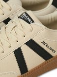 Detail van beige suède sneaker met zwarte strepen en Jack & Jones logo.