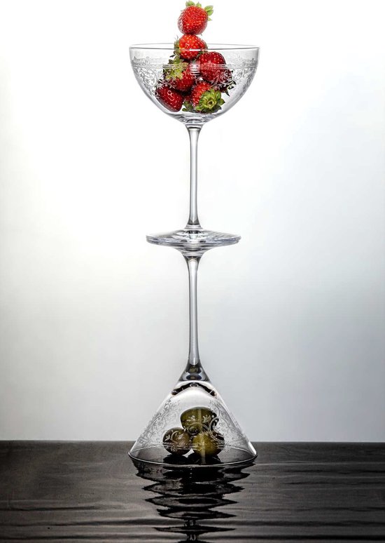 Deux verres à vin empilés, le supérieur rempli de fraises, l'inférieur d'olives.