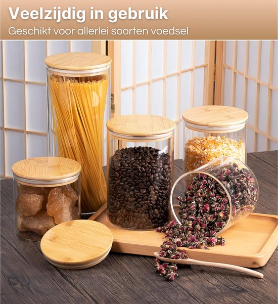 5 bocaux en verre avec couvercles en bambou remplis de spaghettis, grains de café, maïs, morceaux de sucre et boutons de rose.
