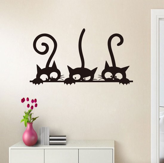 Zwarte katten sticker op een muur boven een dressoir met een vaas.