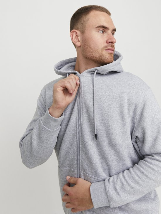 Man sluit een grijze hoodie.