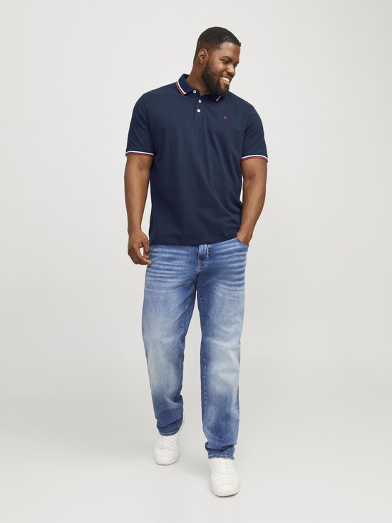 Man in donkerblauwe polo met rode en witte strepen, loopt.