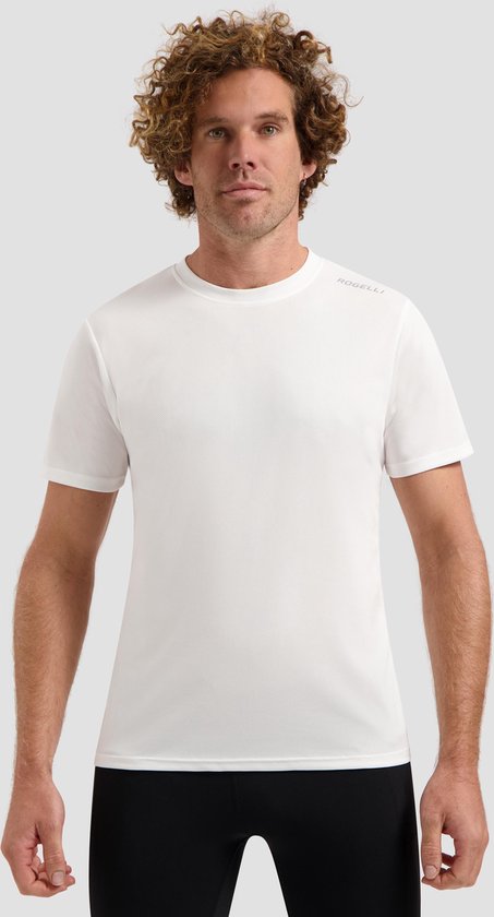 Homme aux cheveux bouclés portant un t-shirt de sport blanc Rogelli et un pantalon de sport noir, regardant la caméra.