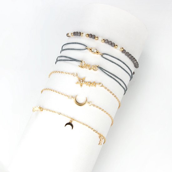 Zes armbanden met een maan-, sterren-, en 'love'-bedeltjes, in goudkleurig metaal en grijze koordjes, met grijze en witte kraaltjes, gepresenteerd op een witte cilinder.