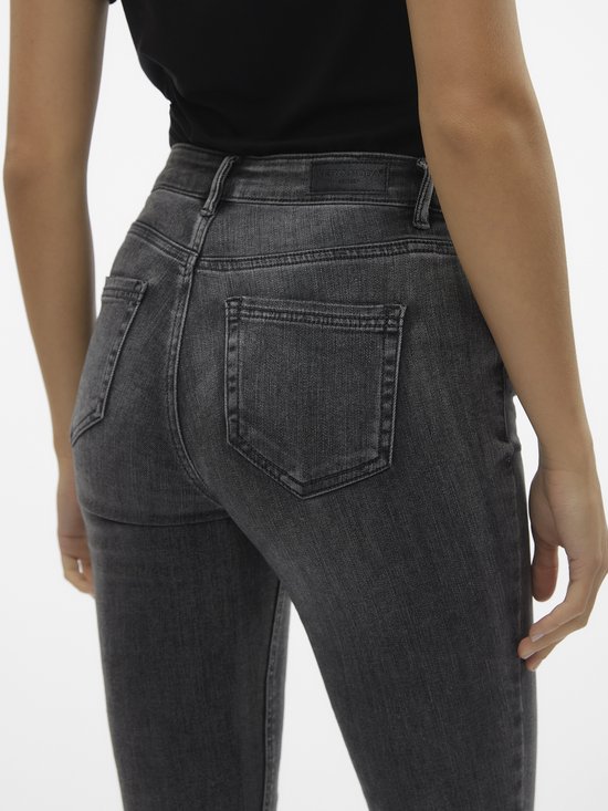 Detail van de achterkant van een grijze skinny jeans.
