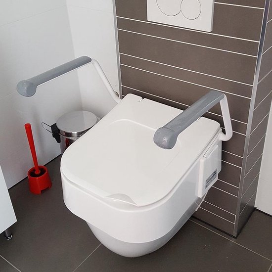 Zijaanzicht van een witte toiletverhoger met grijze armleuningen in een badkamer.