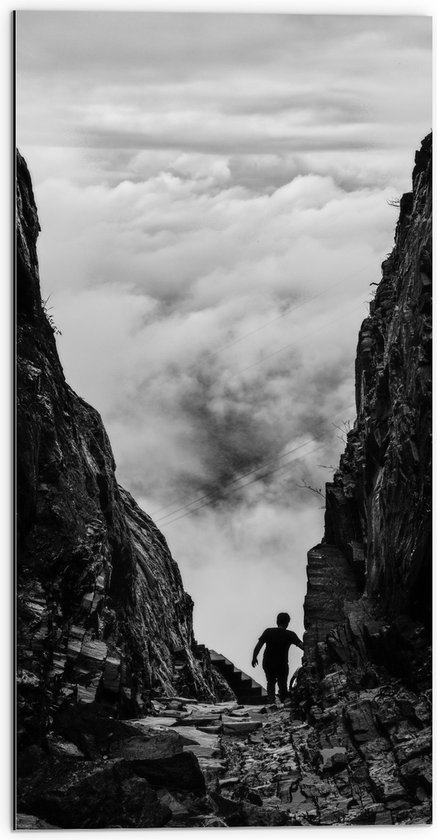WallClassics - Dibond - Man tussen Rotsen boven Wolken in Zwart-wit - 50x100 cm Foto op Aluminium (Met Ophangsysteem)