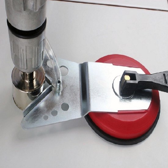 Booraccessoire met rode zuignap, gemonteerd op een boormachine.
