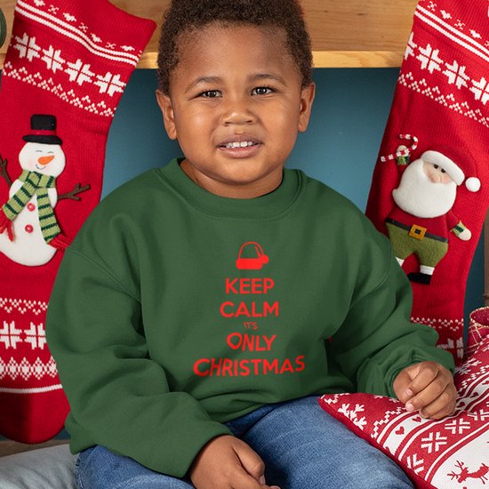 Kind draagt een donkergroene kersttrui met rode tekst: Keep Calm It's Only Christmas en een kerstmutsje.