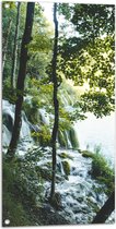 WallClassics - Tuinposter – Waterval tussen de Bomen door - 50x100 cm Foto op Tuinposter  (wanddecoratie voor buiten en binnen)