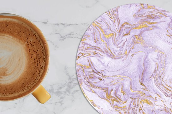 Sous-verre rond à motif marbre lilas et or, à côté d'une tasse de café.