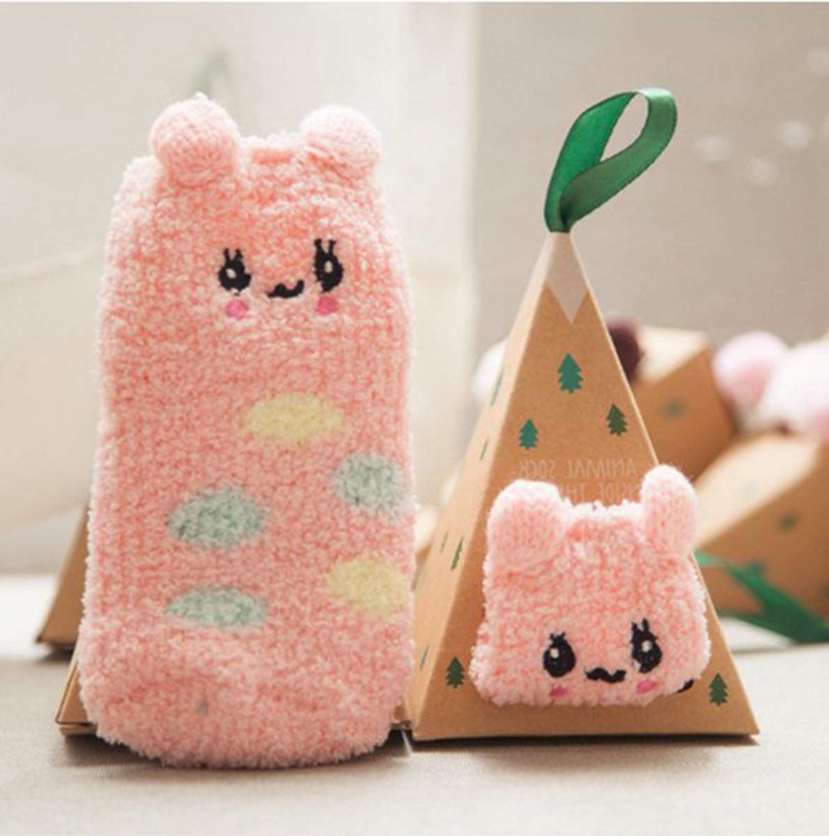 Goedkoopste Kerst baby sokjes roze met schattig dierensnoetje verpakt in een super leuke verpakking die je zo in de kerstboom kan hangen.