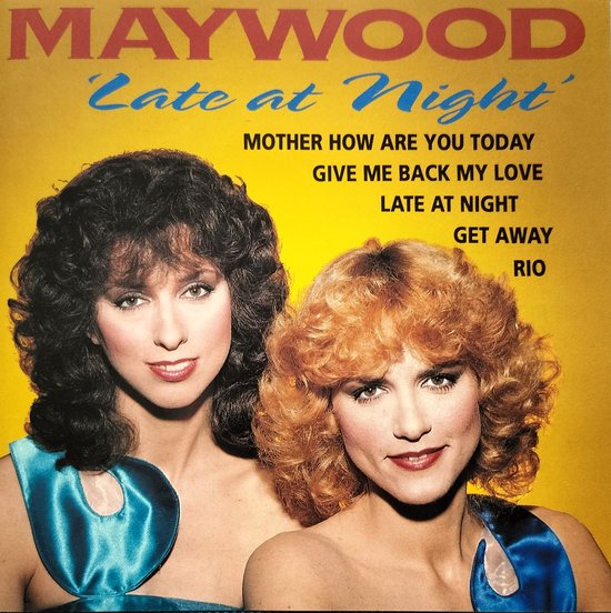 Twee vrouwen met krullend haar, één met donkerbruin en één met blond haar, dragen blauwe topjes. Tekst "MAYWOOD Late at Night" bovenaan.