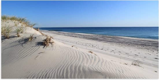 WallClassics - Poster Glanzend – Witte Duinen tegen de Zee - 100x50 cm Foto op Posterpapier met Glanzende Afwerking