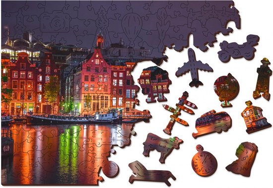 Puzzle en bois d''Amsterdam by Night' avec des pièces partiellement assemblées et diverses pièces de forme individuelles, dont un avion, un moulin et une maison de canal.