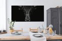 Toile noir et blanc d'un taureau sur fond sombre, au-dessus d'une table à manger.